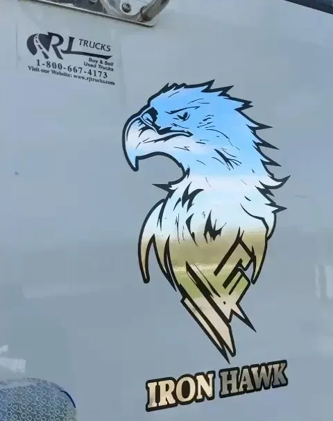 Printed eagle graphic and Iron Hawk lettering applied to the door of a white highway tractor