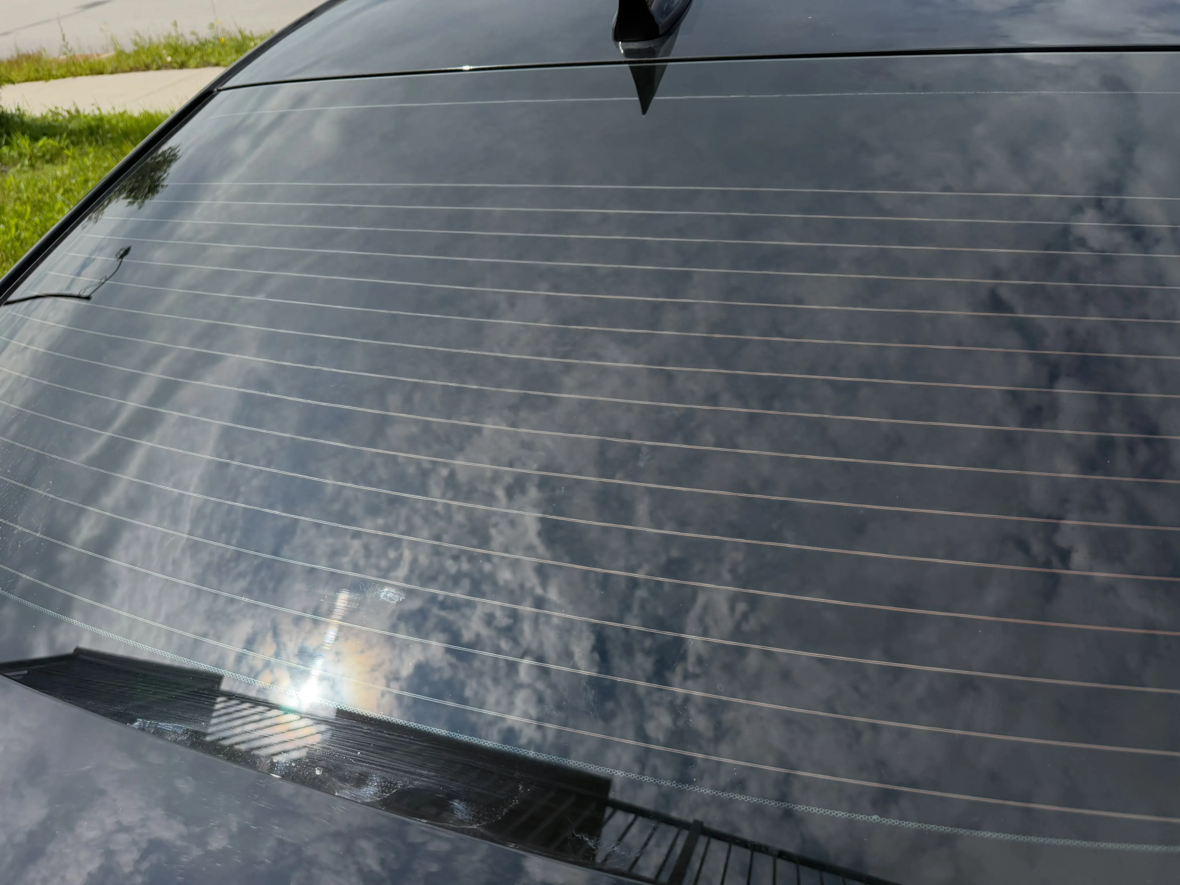 Bare rear window on a dark sedan before the decal was applied