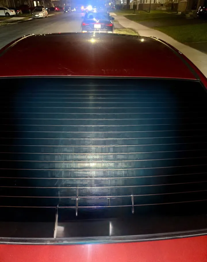 Bare rear window on a red sedan before the graphics were applied